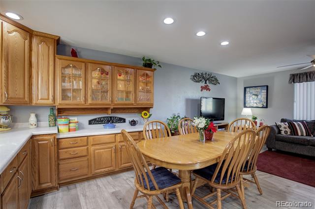 Dining area with a large wooden table, matching chairs, and extensive honey-colored cabinetry.