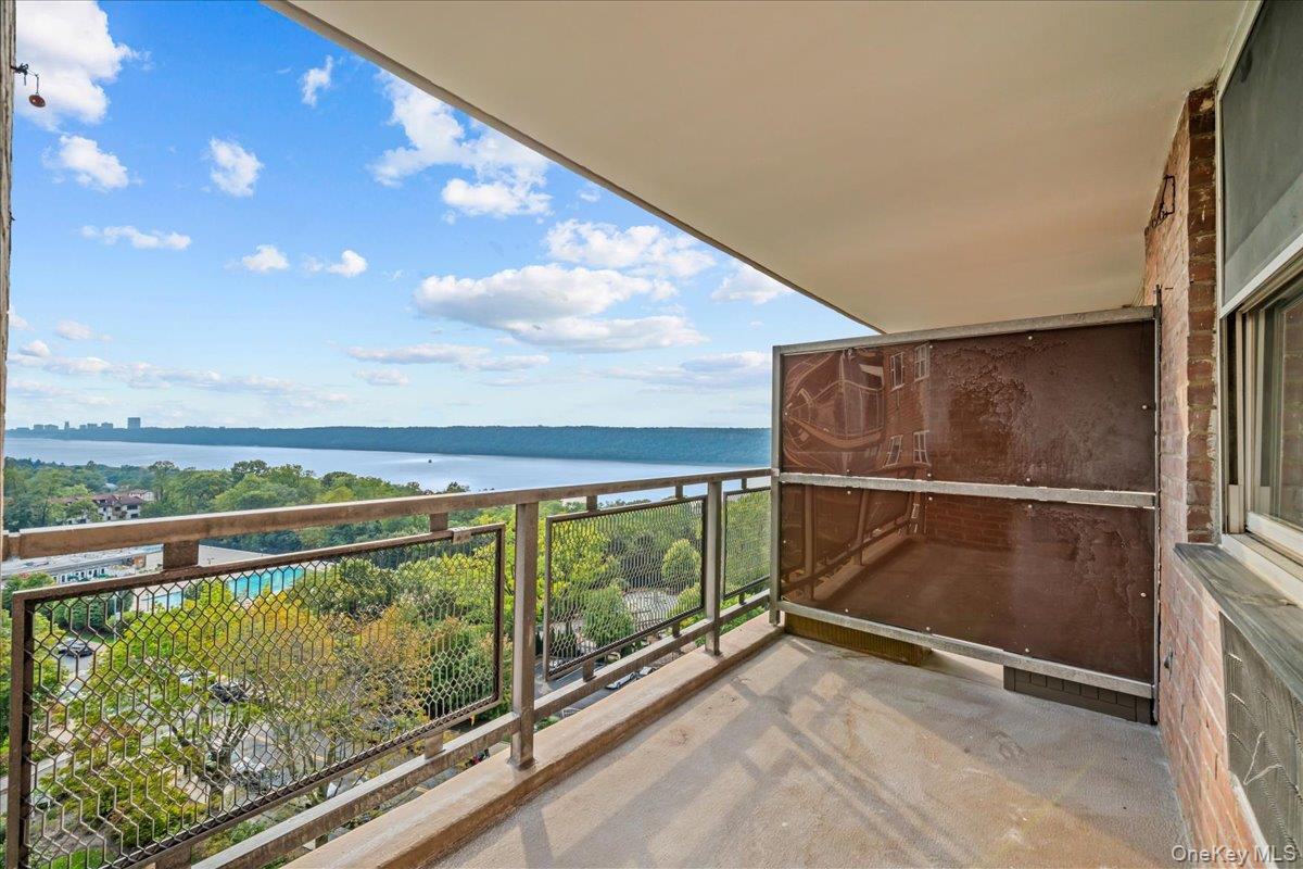 Covered balcony overlooking the Hudson River and wooded grounds.