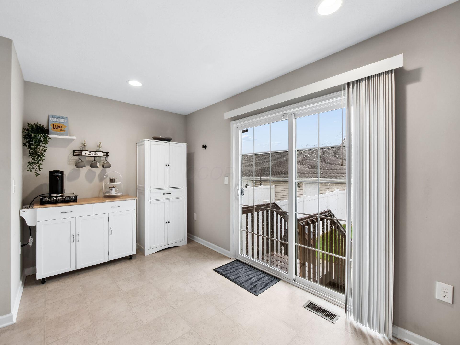 Coffee nook with white cabinets and a sliding glass door opening onto a small deck.