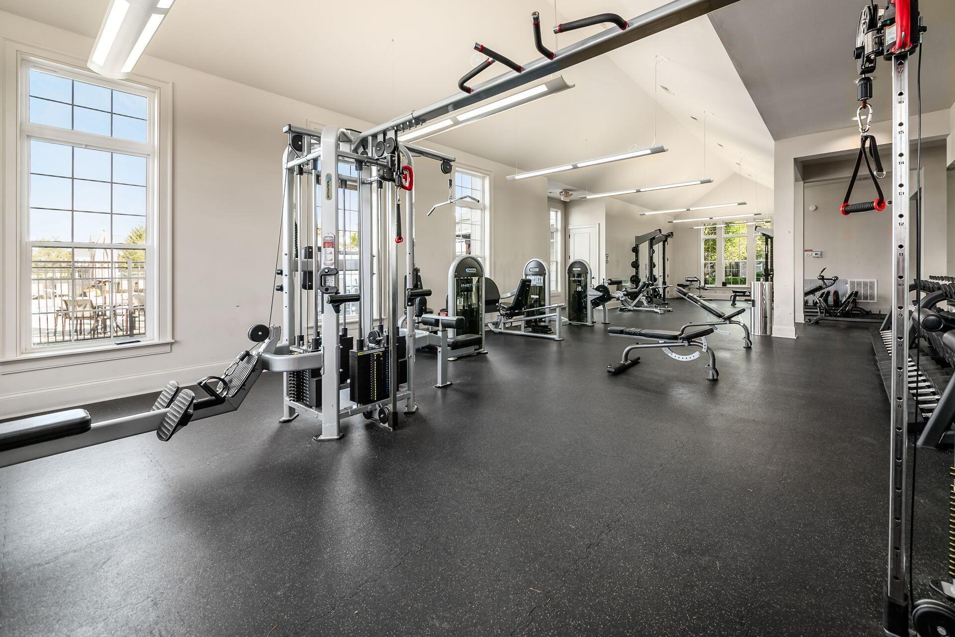 Fitness room with cable machines, weight benches, and dumbbell racks.