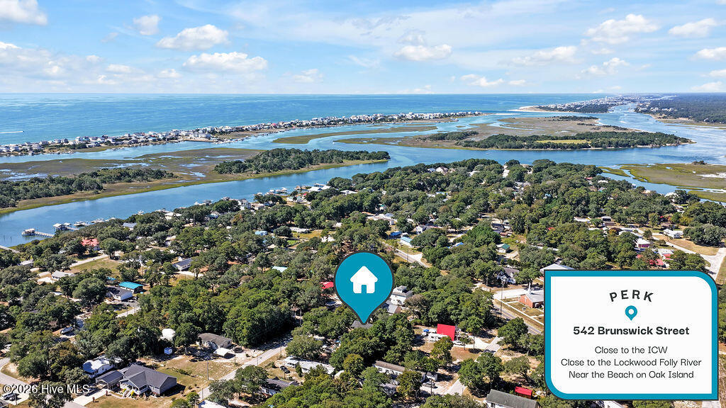 Aerial view of a wooded neighborhood beside coastal waterways, with a pin marking 542 Brunswick Street.