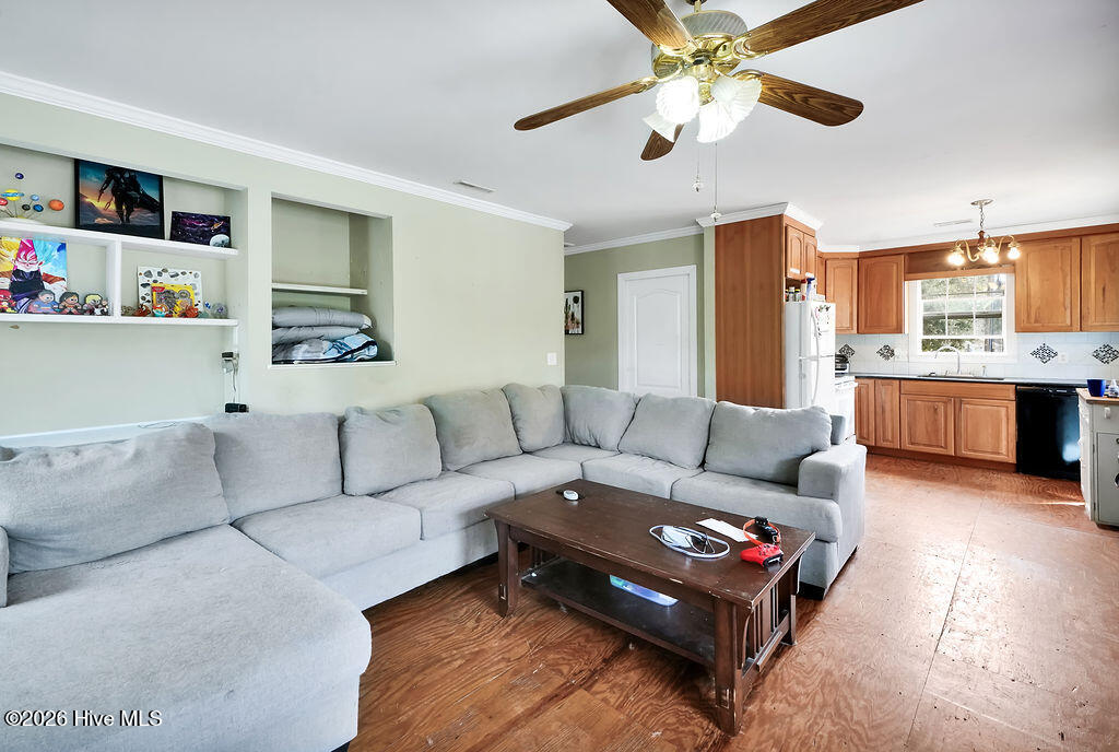 Living room with a large gray sectional sofa and an adjoining kitchen with wood cabinets.
