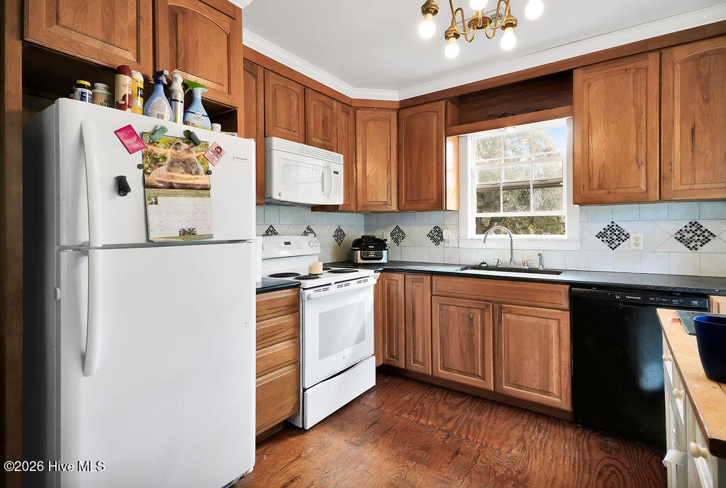 Kitchen with warm wood cabinets, tiled backsplash, and a window above the sink.