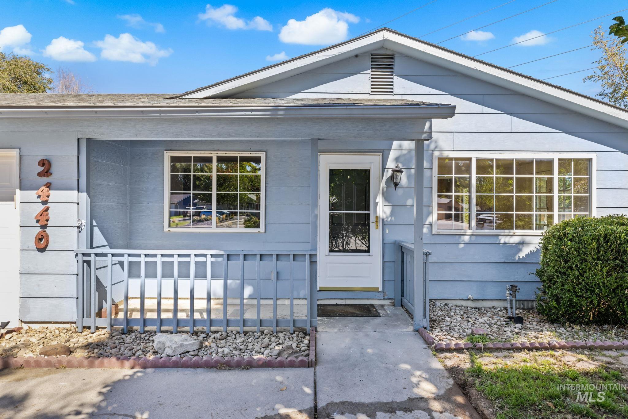 Light blue house with a covered porch, white trim, and the number 2446.