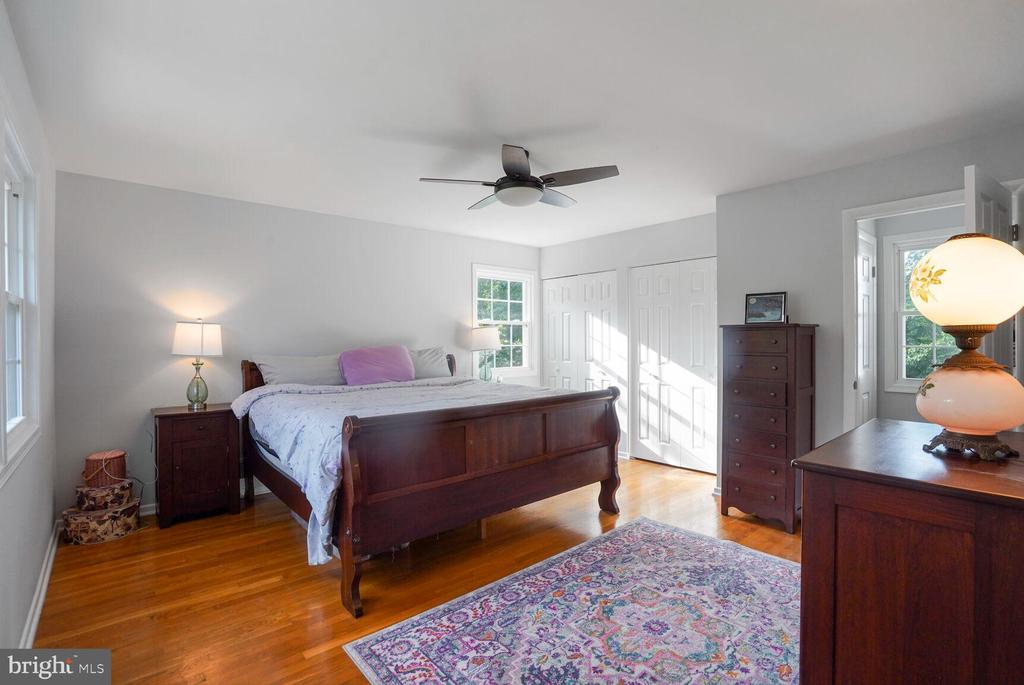 Bedroom with a dark wood bed, hardwood floors, and a colorful patterned rug.