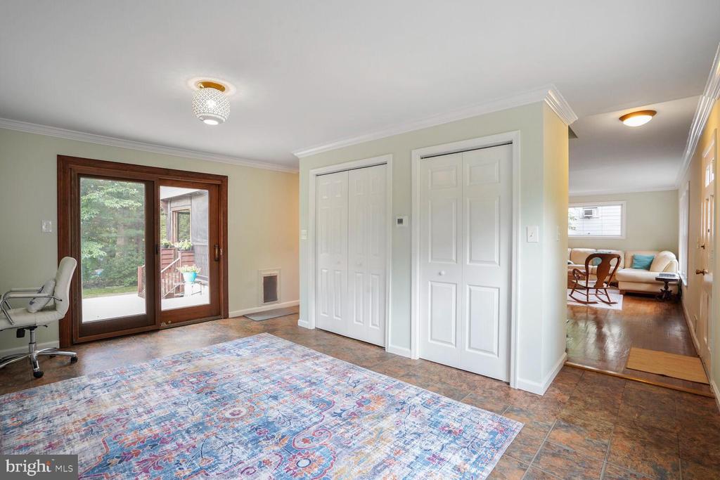 Bright room with sliding patio doors, double closet doors, and a colorful patterned rug.