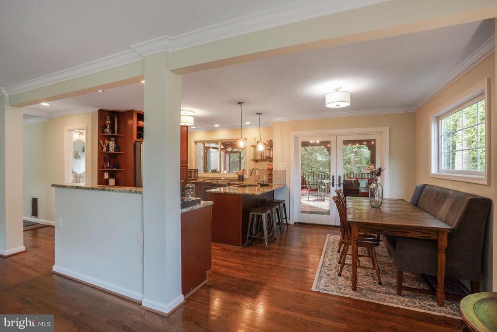 Kitchen and dining area with a granite island, hardwood floors, and sliding doors to a deck.