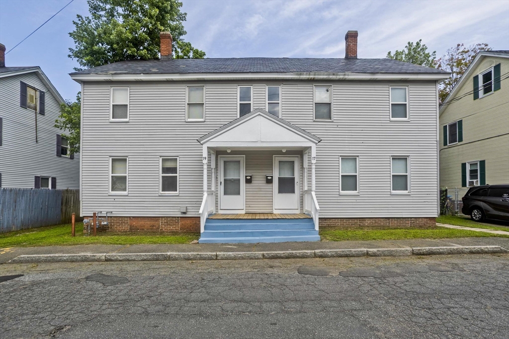 Two-story gray-sided home with twin front doors and blue-painted steps.