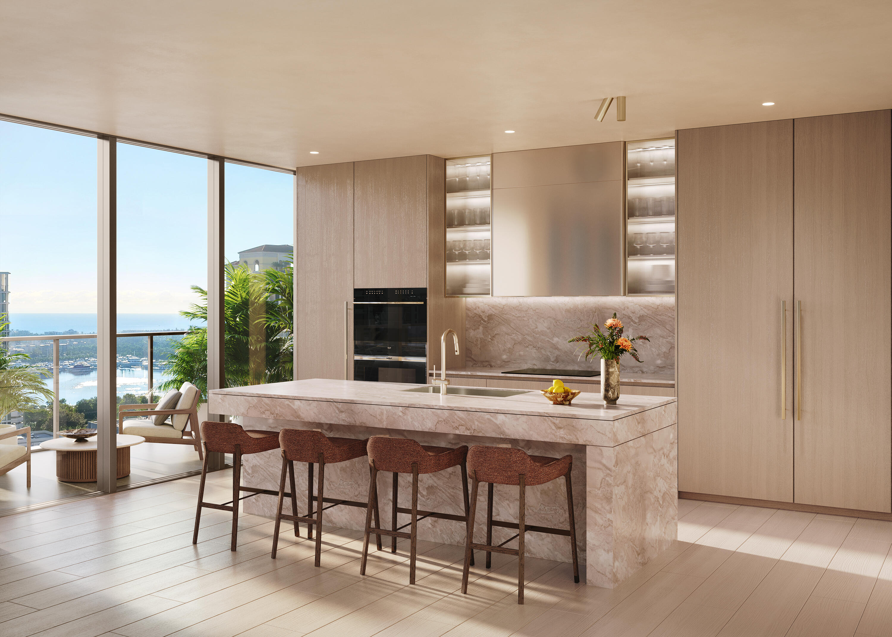 Modern kitchen with a marble island and waterfront views through floor-to-ceiling windows.