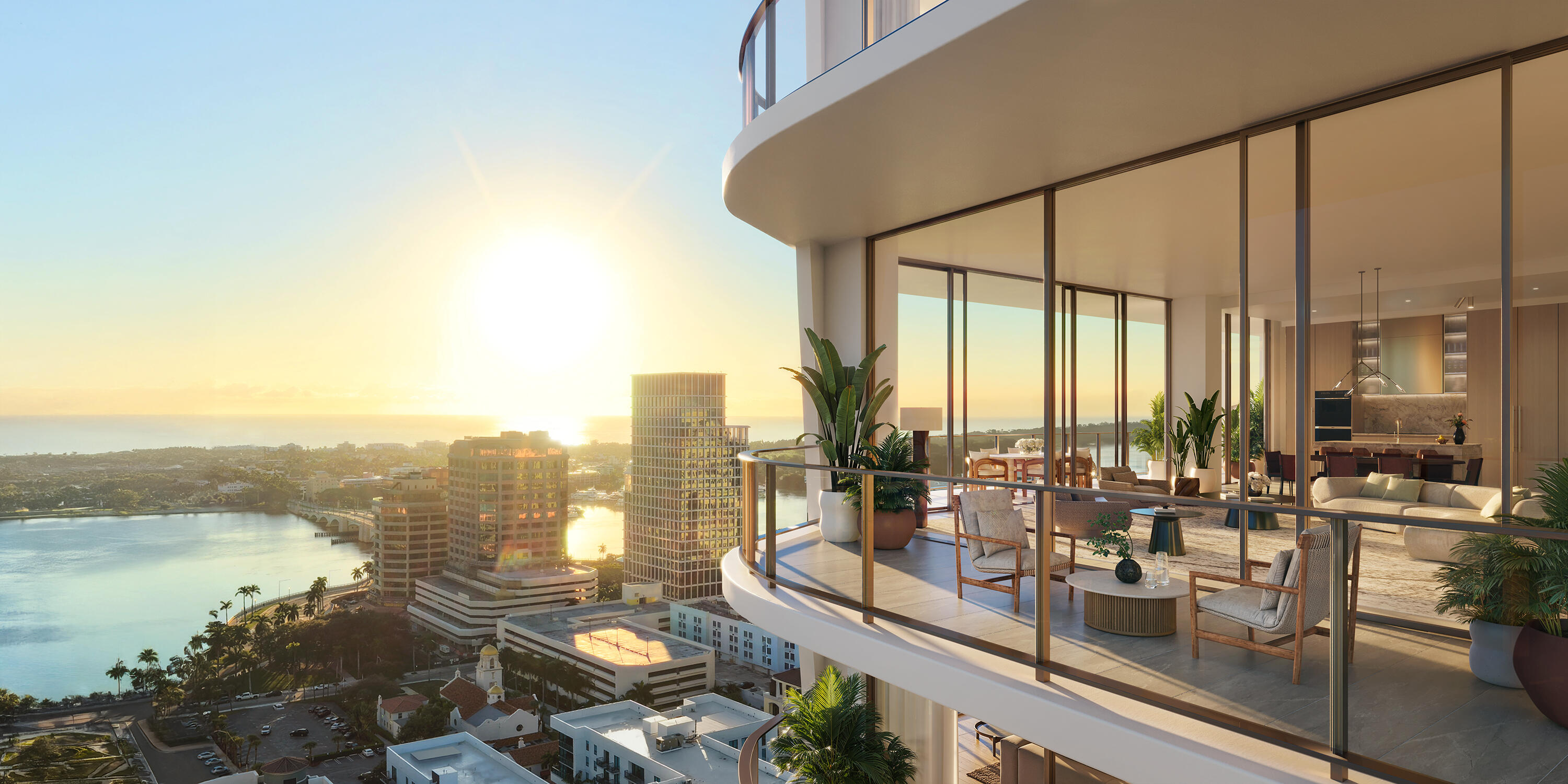 Furnished high-rise terrace overlooking the waterfront and city skyline at sunset.