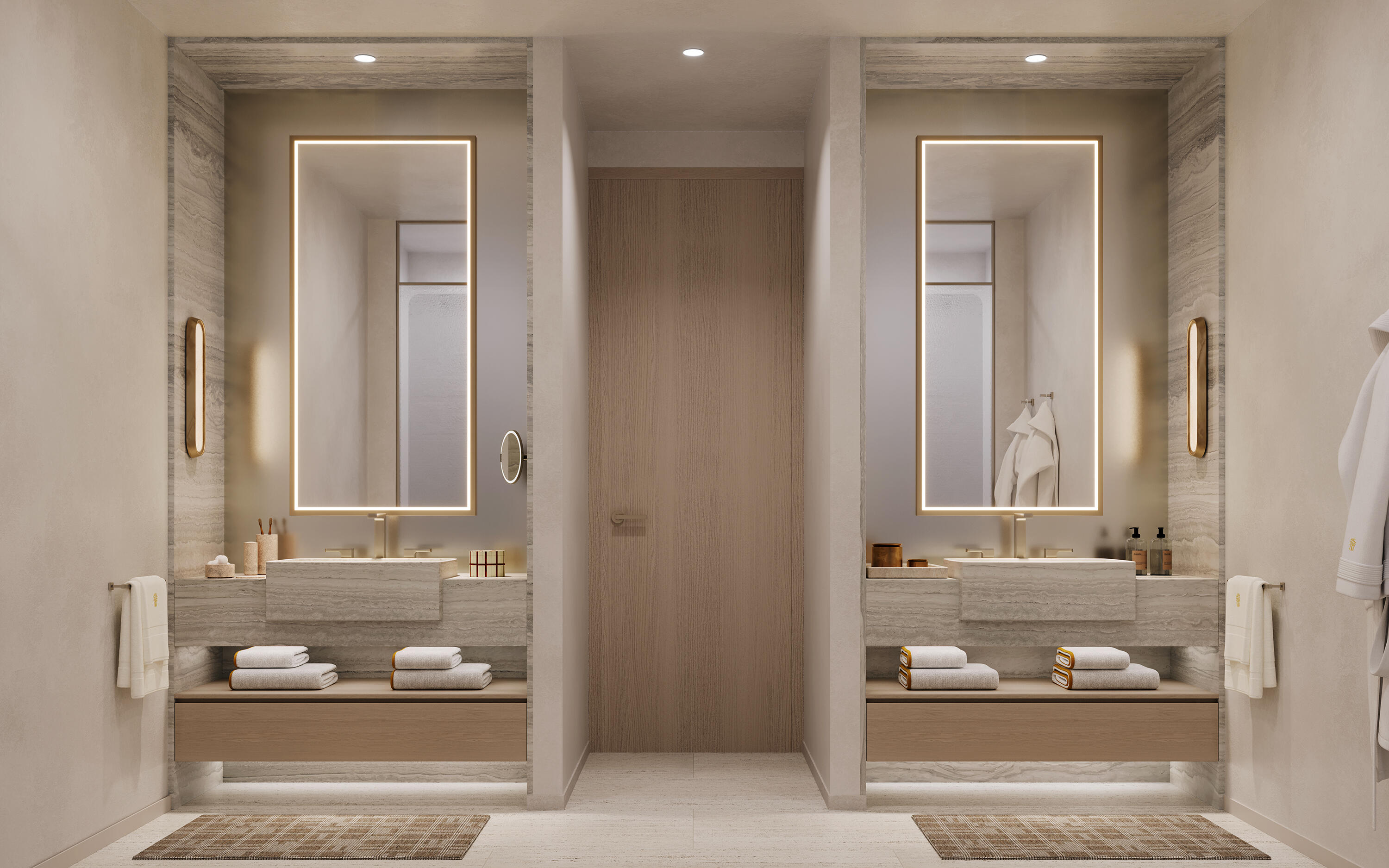 Luxury bathroom with twin floating stone vanities and illuminated mirrors flanking a central wood door.