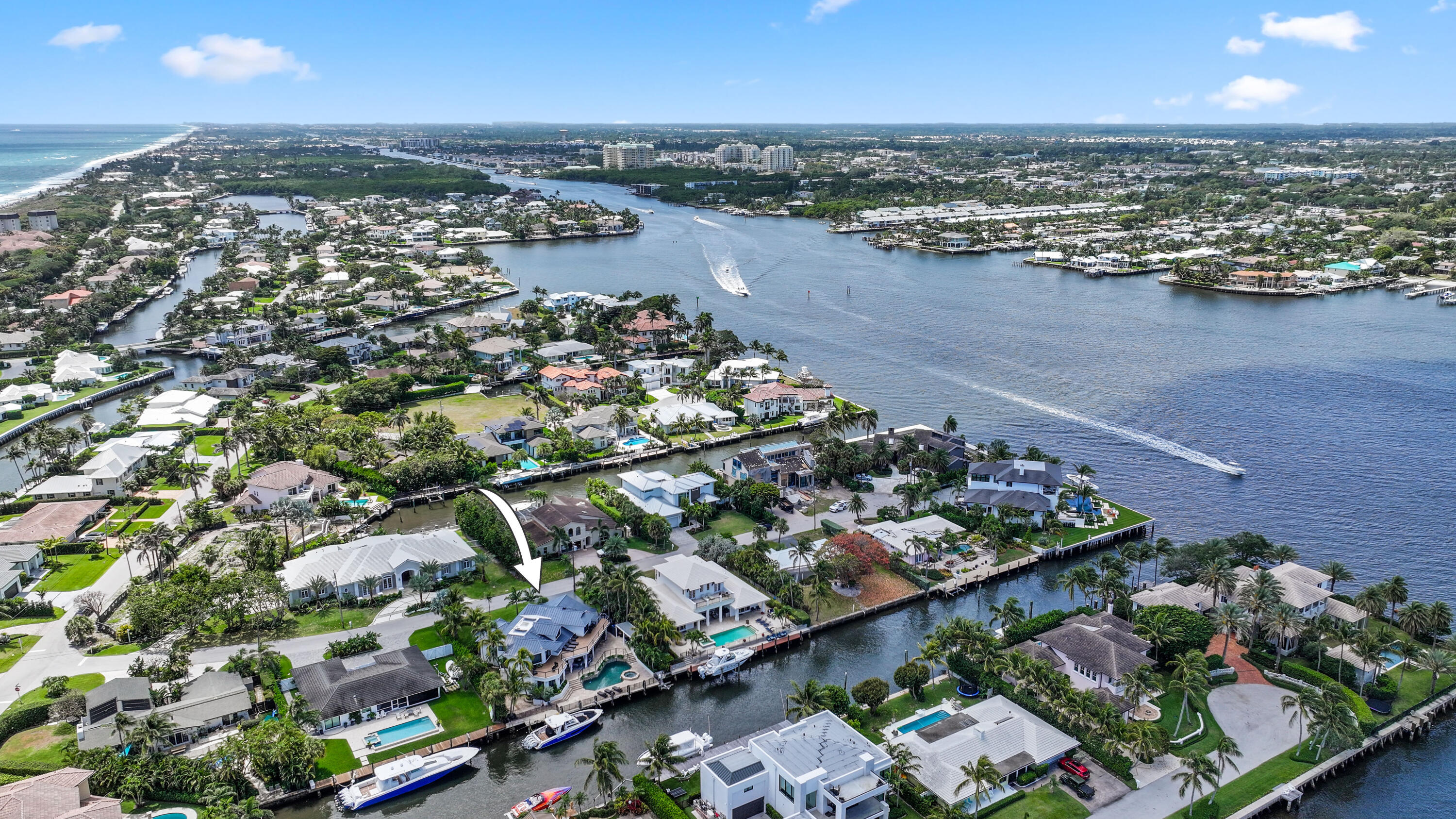 Aerial view of 125 Marlin Drive, marked by an arrow among homes beside a canal.