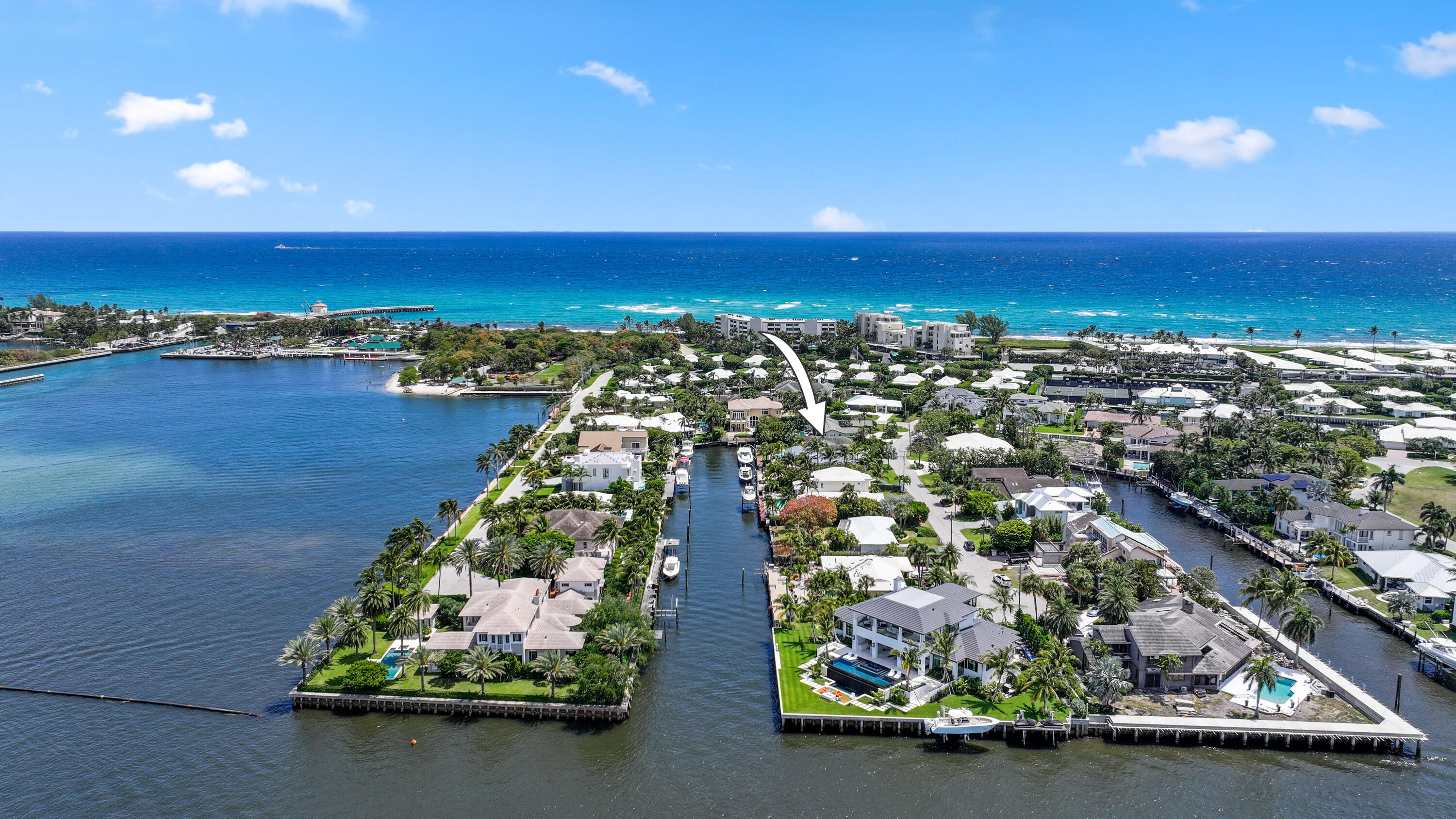 Aerial view of waterfront homes and canals beside the Atlantic, with an arrow marking 125 Marlin Drive.