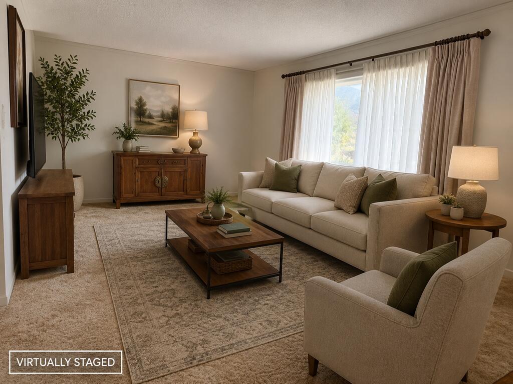 Living room with beige seating, green pillows, a wooden coffee table, and a large curtained window.