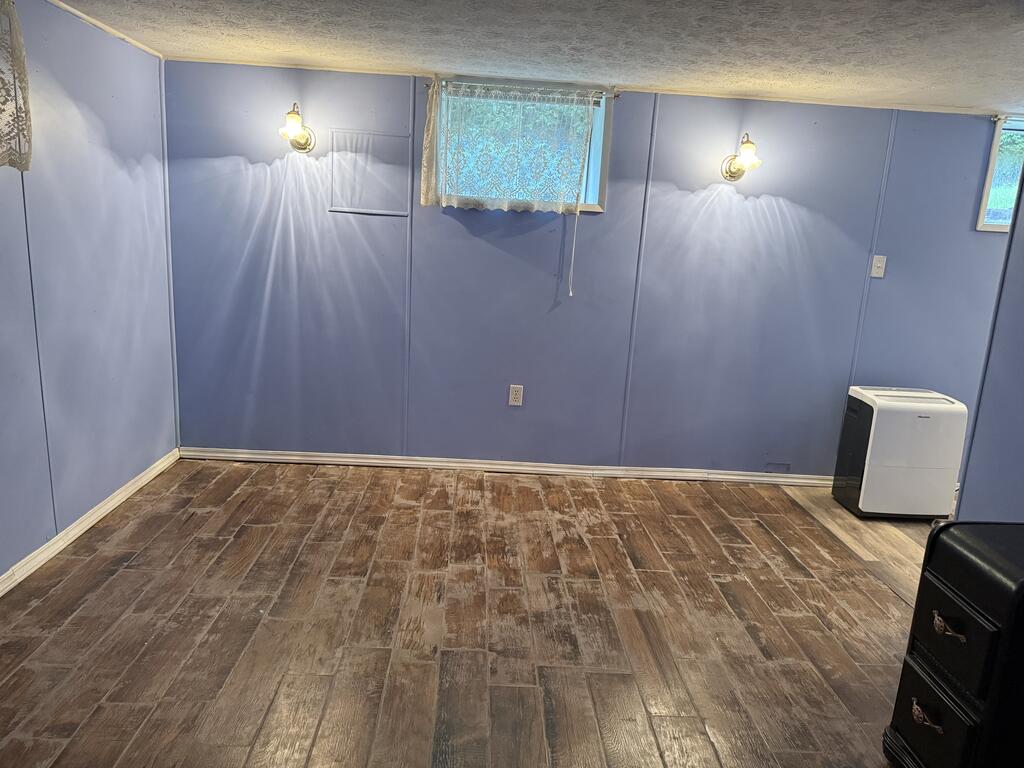 Room with blue walls, patterned tile flooring, two wall sconces, and small curtained windows.