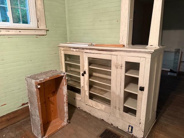 Interior room with a distressed built-in cabinet, open shelves, and pale green walls.