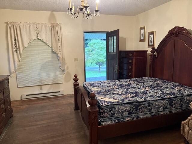 Bedroom with a carved four-poster bed and floral bedding beside an open door to the lawn.