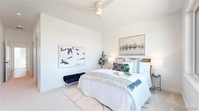 Bright staged bedroom with a white bed, abstract art, and a large window.
