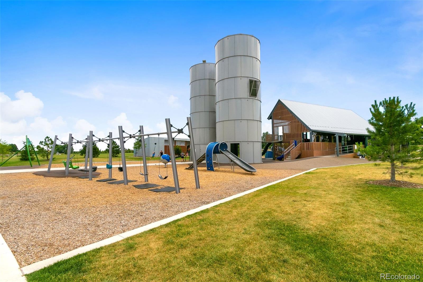 Community playground with swings, slides, two tall towers, and a covered pavilion.