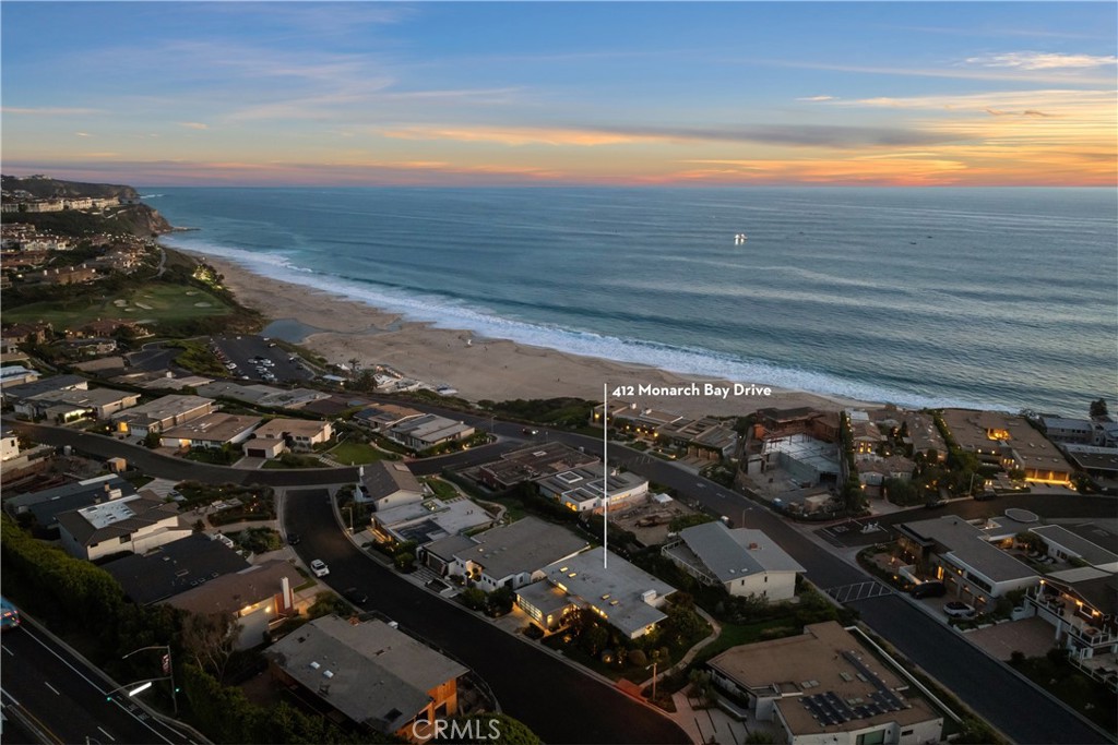 Aerial view of Monarch Bay homes and coastline at sunset, with 412 Monarch Bay Drive marked.