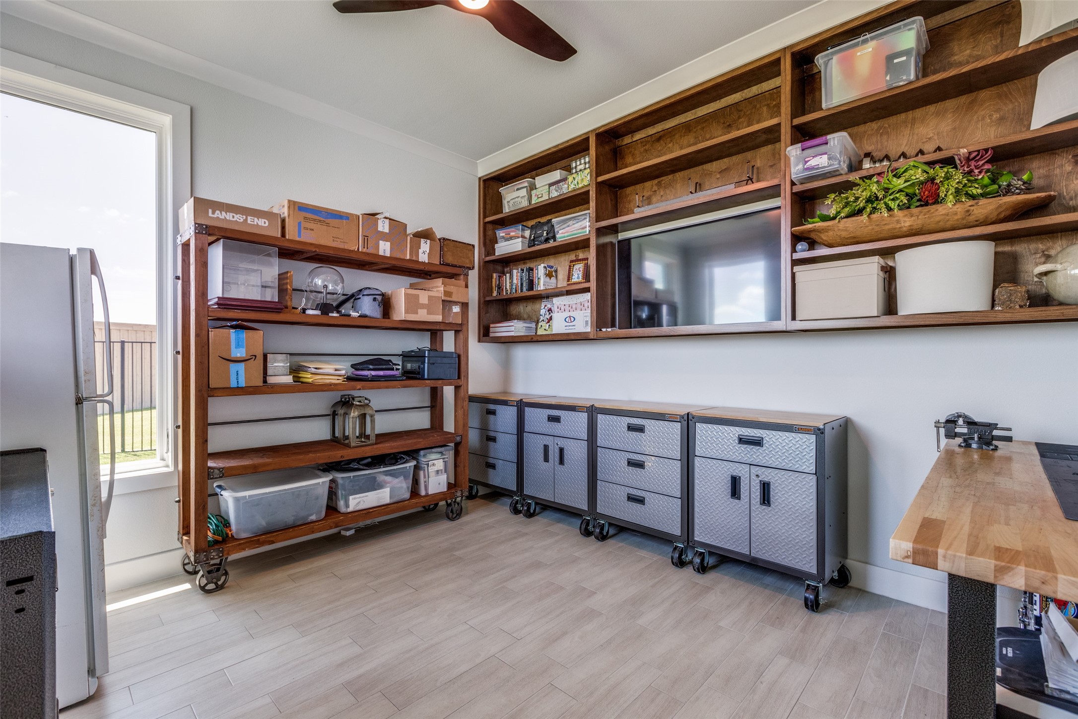 Workshop with custom wood shelving, rolling metal cabinets, and a butcher-block workbench.