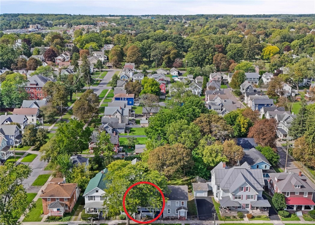 Aerial view of a tree-lined residential neighborhood, with the featured home circled in red.