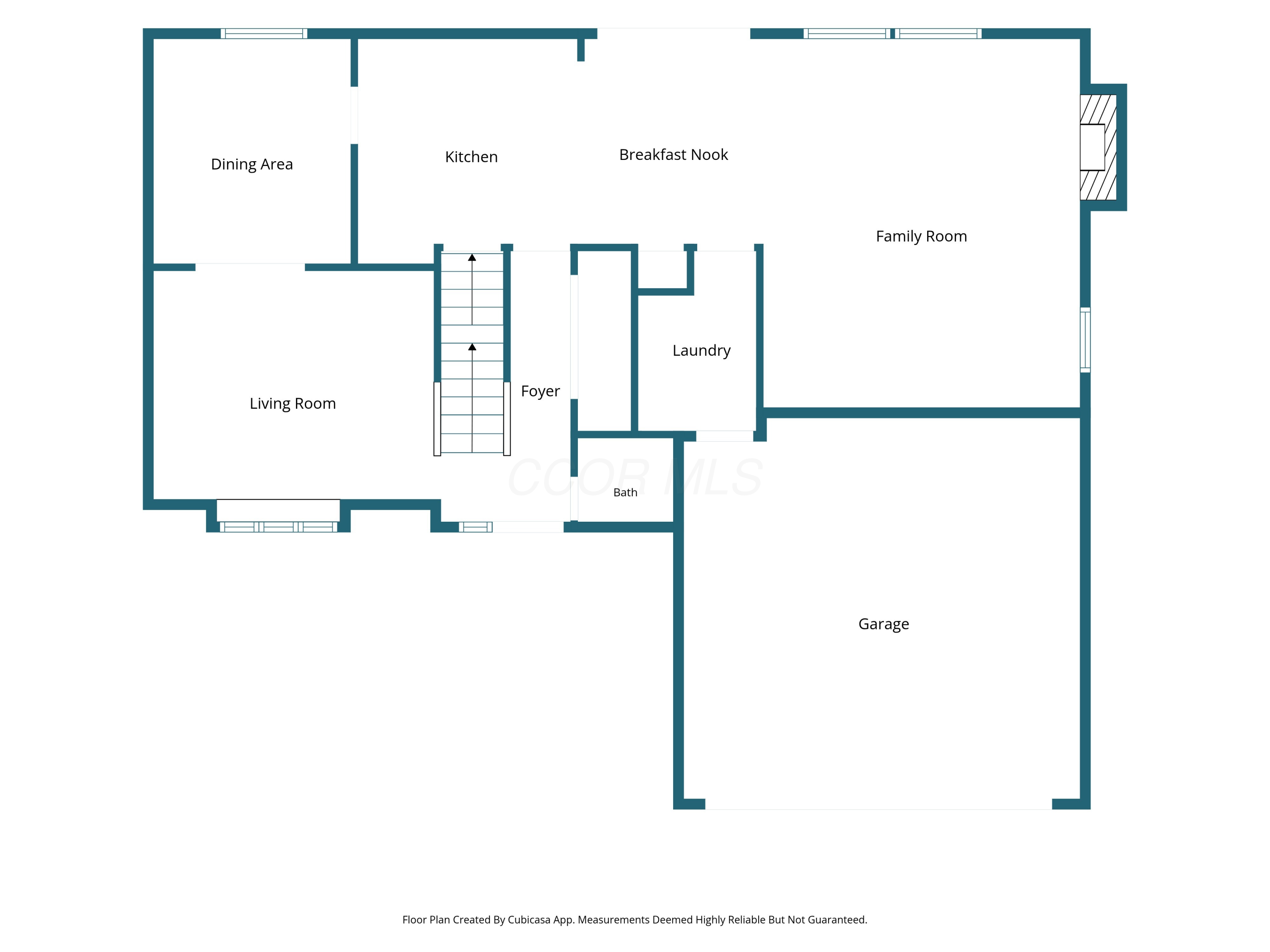 Floor plan showing the home’s living areas, kitchen, laundry, bath, garage, and central staircase.