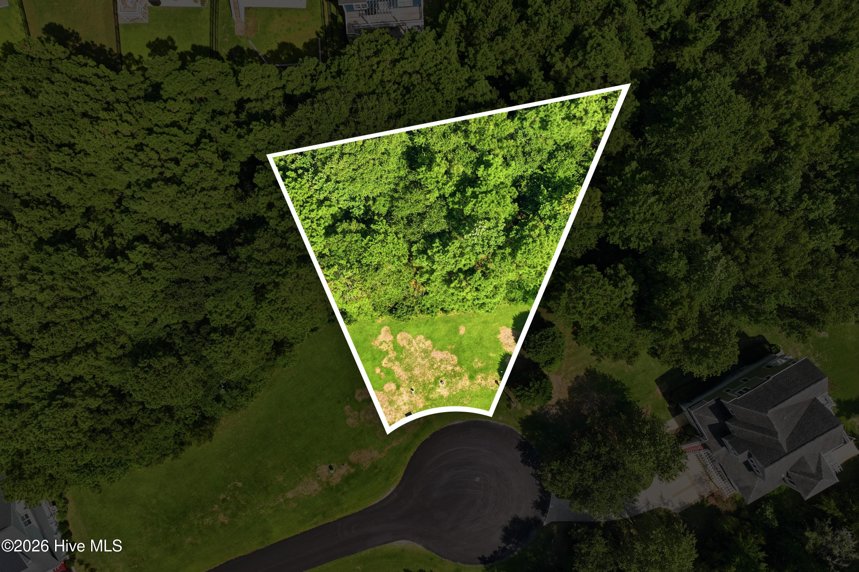 Aerial view of a wooded lot outlined in white beside a cul-de-sac.