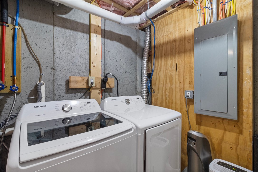 Basement laundry area with a Samsung washer and dryer beside an electrical panel.
