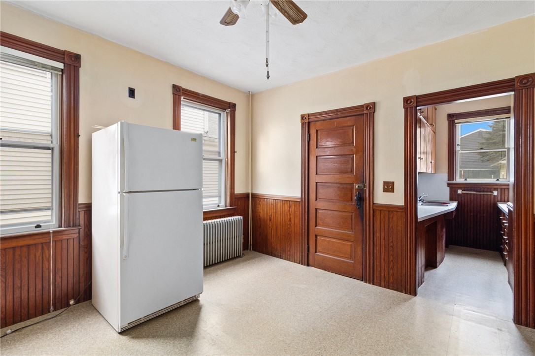 Kitchen with a white refrigerator, dark wood trim, and a doorway to the sink area.
