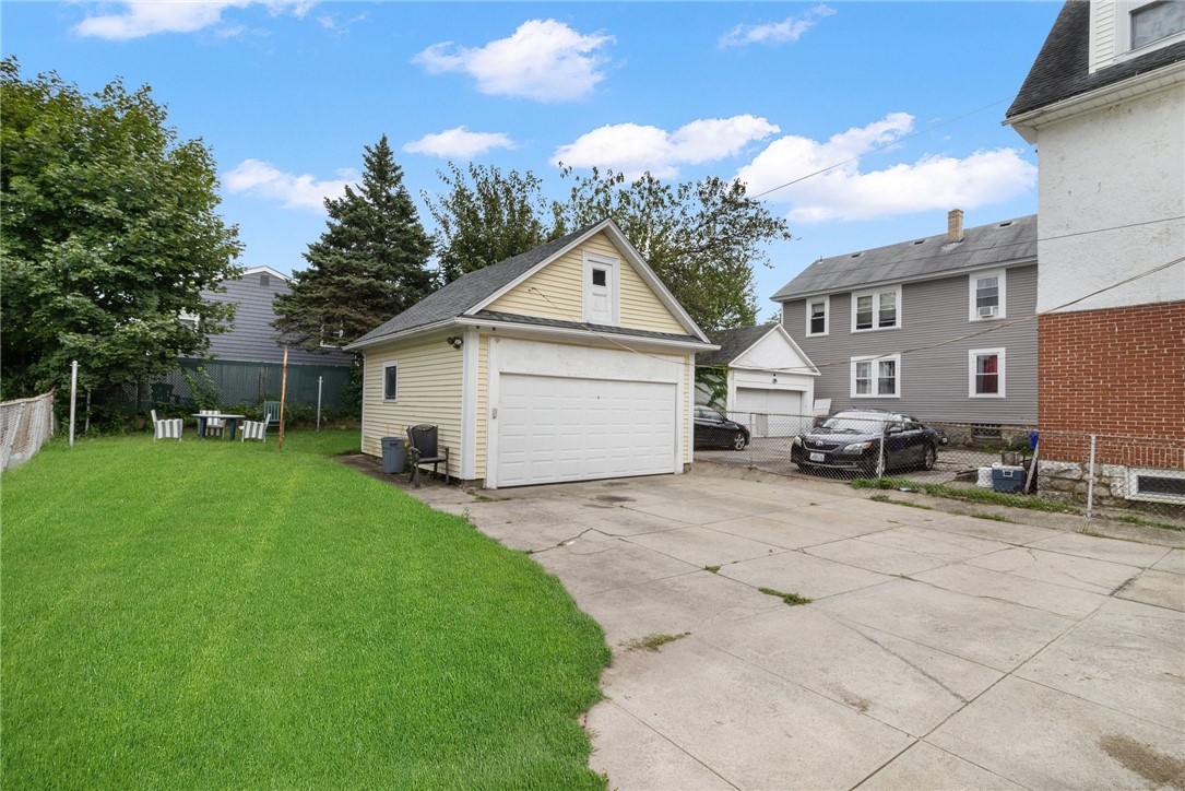 Detached garage beside a paved driveway and green lawn.