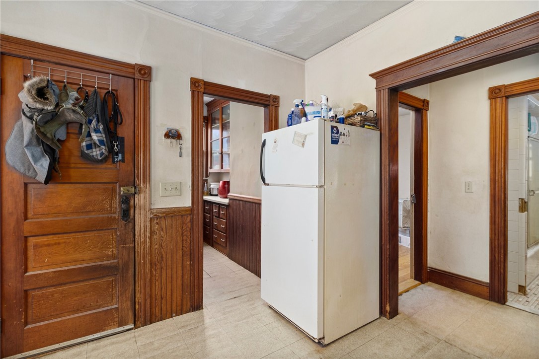 Kitchen with a white refrigerator, dark wood cabinetry, and ornate wood trim.