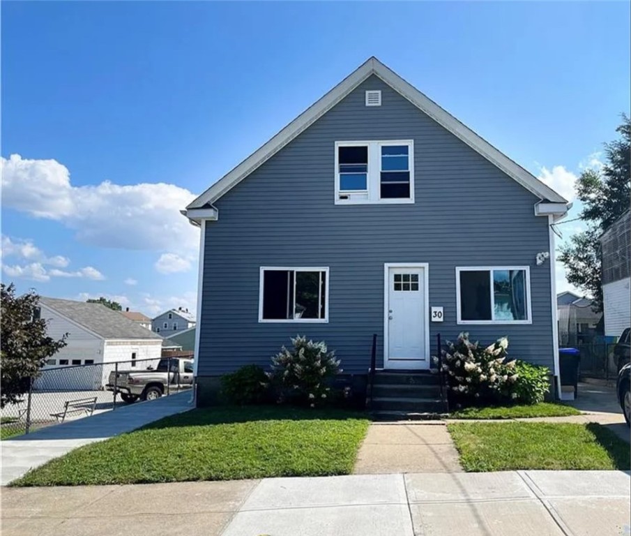 Blue two-story gable-front house with white trim, front lawn, and walkway to the door.