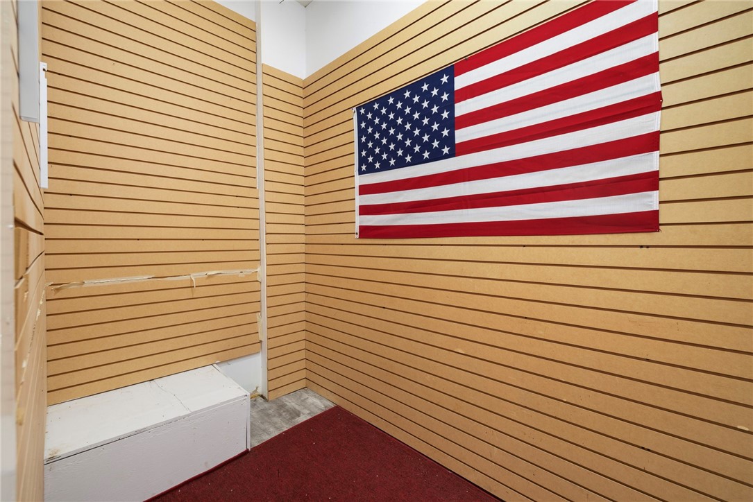 Interior room with tan slatwall panels, a large American flag, and red carpet.