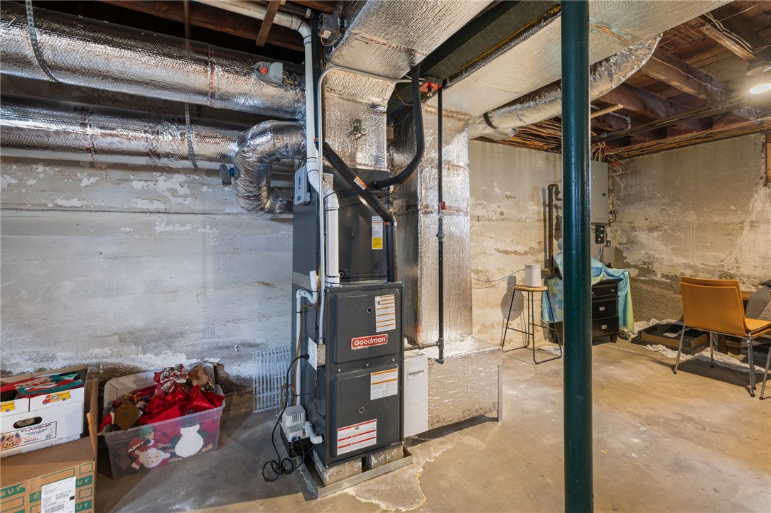 Unfinished basement with a Goodman furnace, exposed ductwork, and concrete floor.