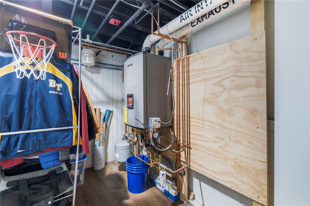 Basement utility room with a boiler, exposed copper pipes, and stored sports equipment.