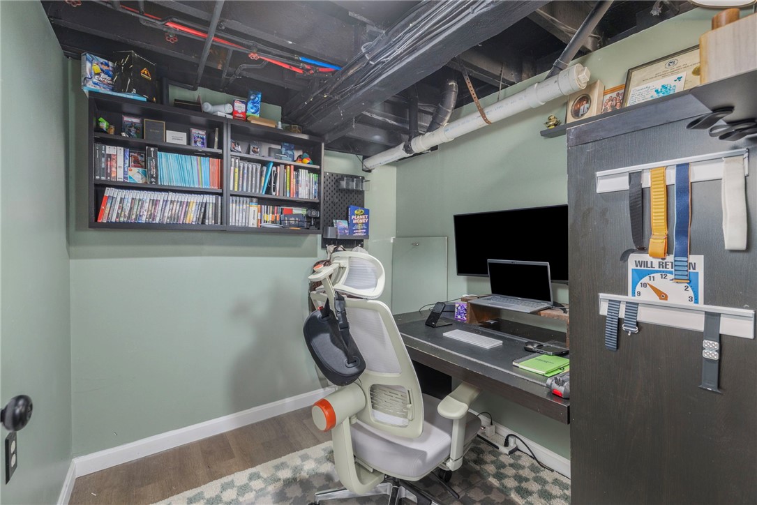 Home office with a white ergonomic chair, computer desk, and wall-mounted bookshelves.