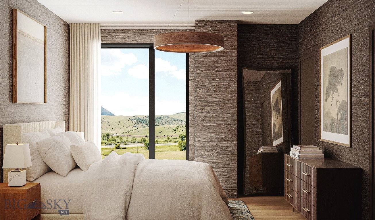 Furnished bedroom with a white bed and a large window overlooking green rolling hills.