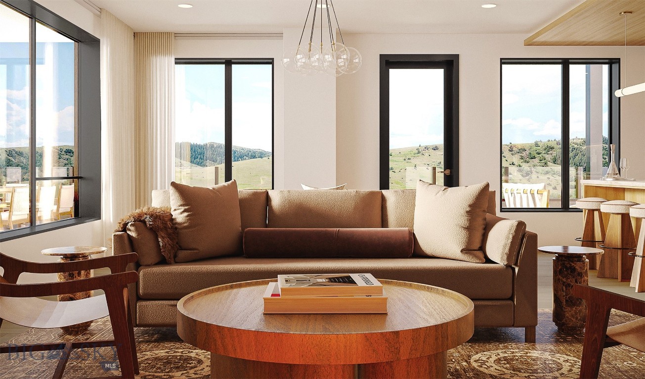 Furnished living room with a brown sofa and wide windows overlooking rolling hills.