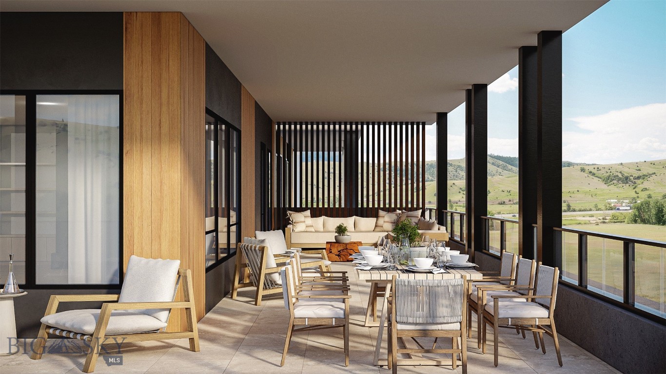 Furnished covered terrace with dining and lounge seating overlooking green rolling hills.