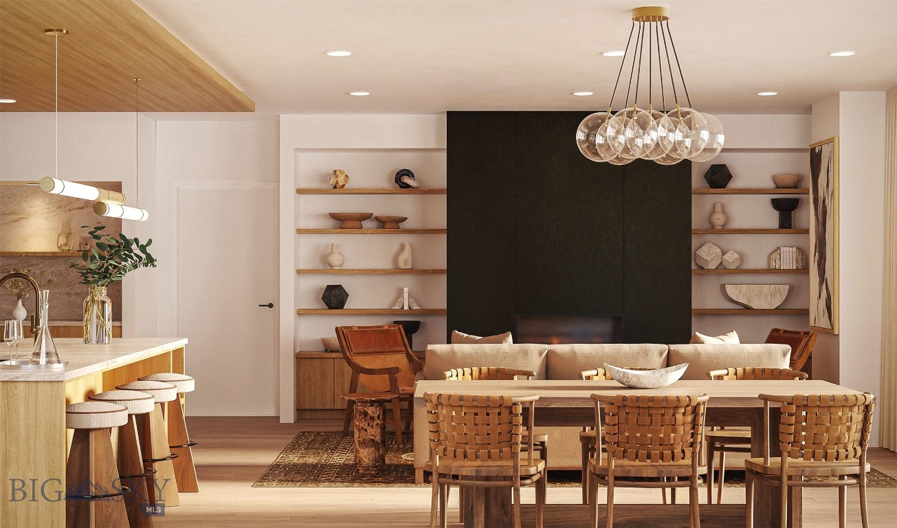 Open-plan dining and living area with a wooden table, woven chairs, and black fireplace wall.