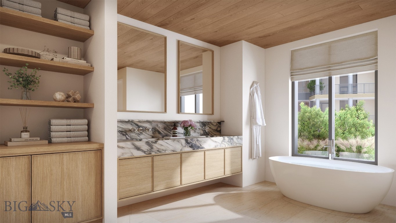 Bathroom with a freestanding tub, veined marble backsplash, light-wood vanity and window overlooking greenery.