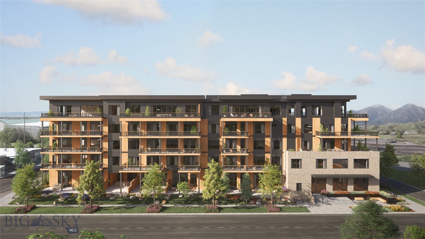 Modern multistory apartment building with balconies and landscaped grounds, set against distant mountains.