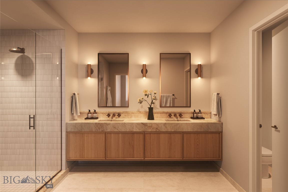 Bathroom with a double-sink wood vanity, stone countertop, and glass-enclosed tiled shower.