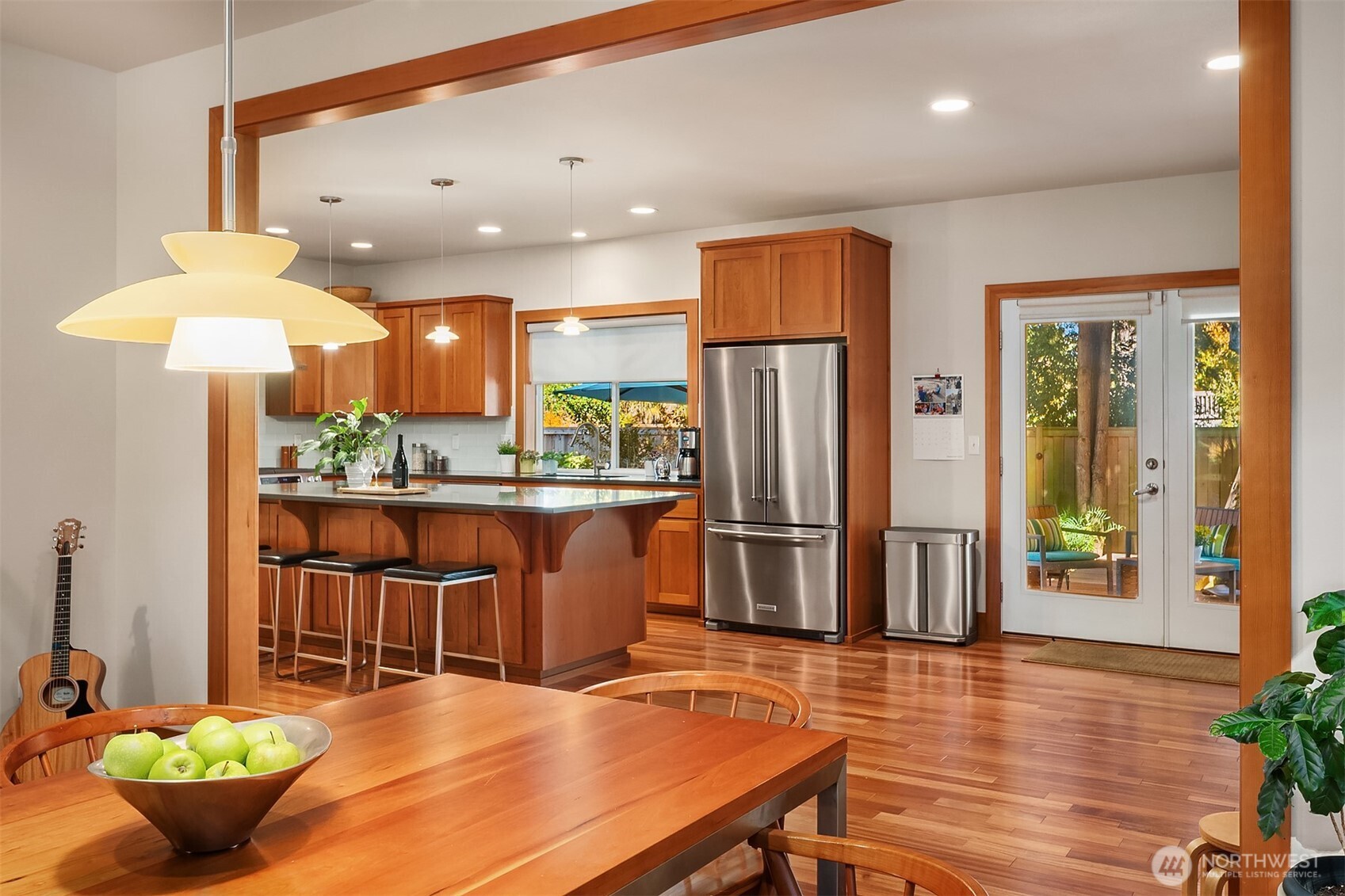 Kitchen with warm wood cabinets, a breakfast island, stainless steel appliances, and glass doors to the patio.