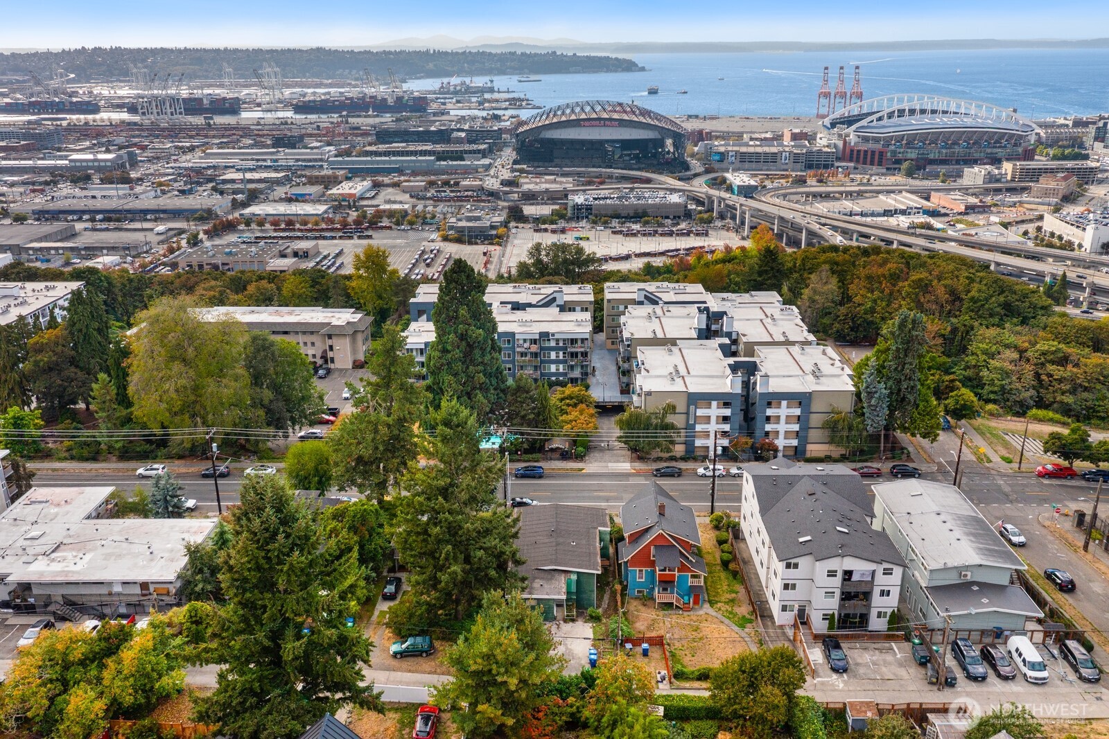 Aerial view of Seattle neighborhood with stadiums, port facilities, and Elliott Bay.