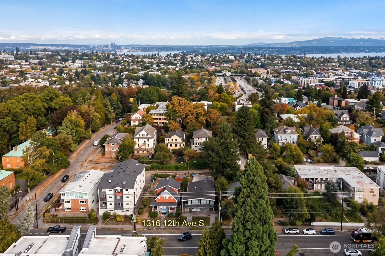 Aerial view of a Seattle neighborhood with autumn trees, water, and the downtown skyline.