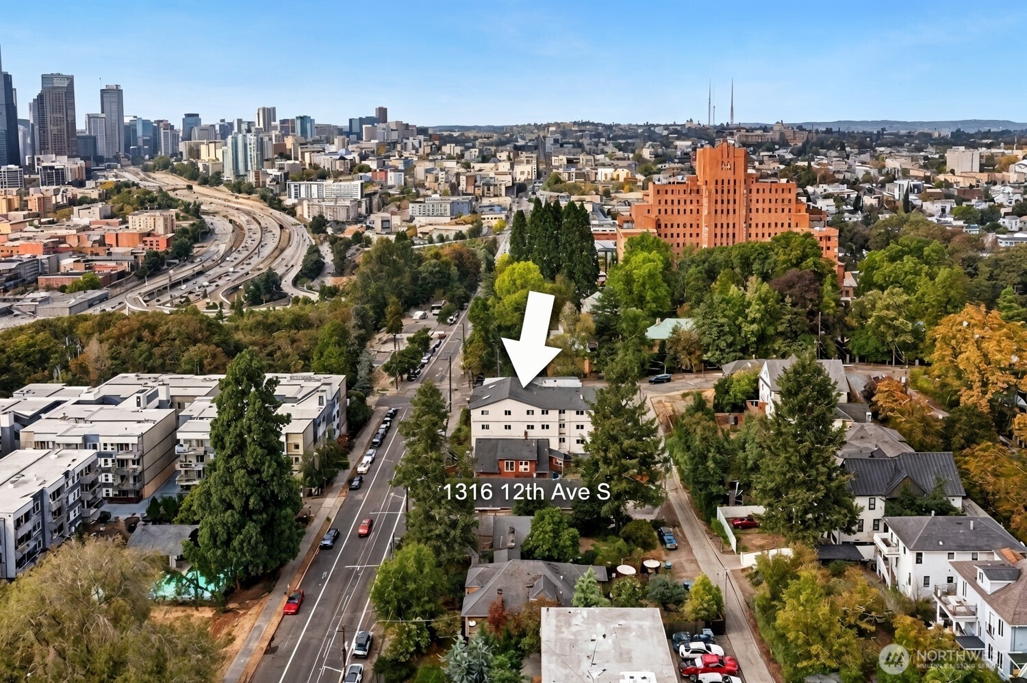 Aerial view of 1316 12th Ave S, marked by an arrow, with the Seattle skyline in the distance.