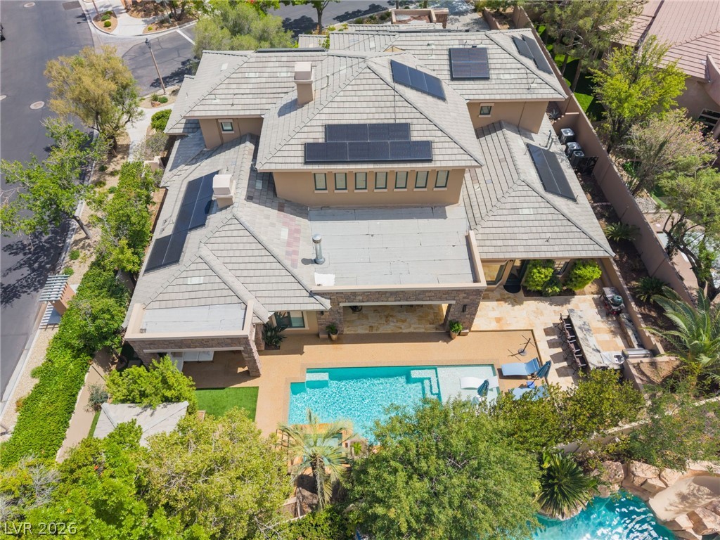 Aerial view of a Las Vegas home with rooftop solar panels and a backyard pool.