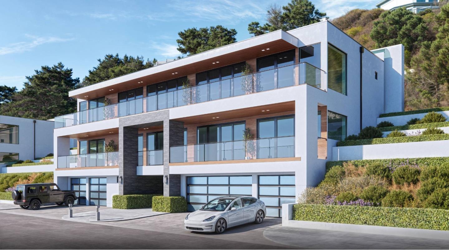 Modern white hillside home with glass balconies, stone accents, and multiple garage bays.